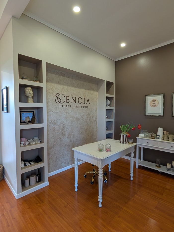 La recepción del estudio, con el logo de Scencia en la pared y una mesa blanca